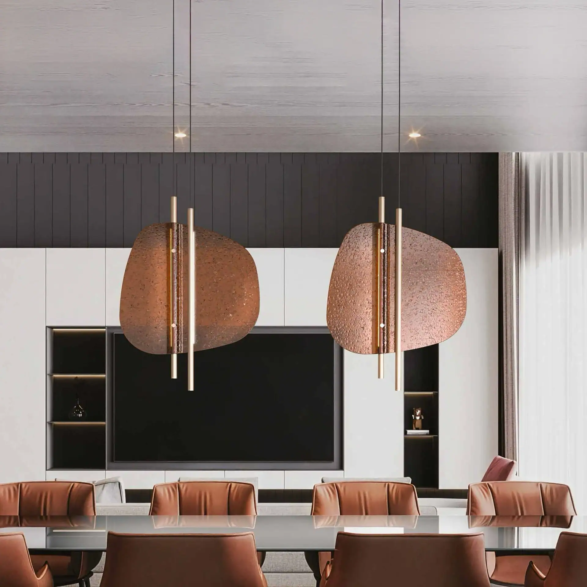 A modern dining or conference room with a glass table, brown leather chairs, and two unique copper-toned pendant lights. A large TV is integrated into a white and dark grey wall unit.