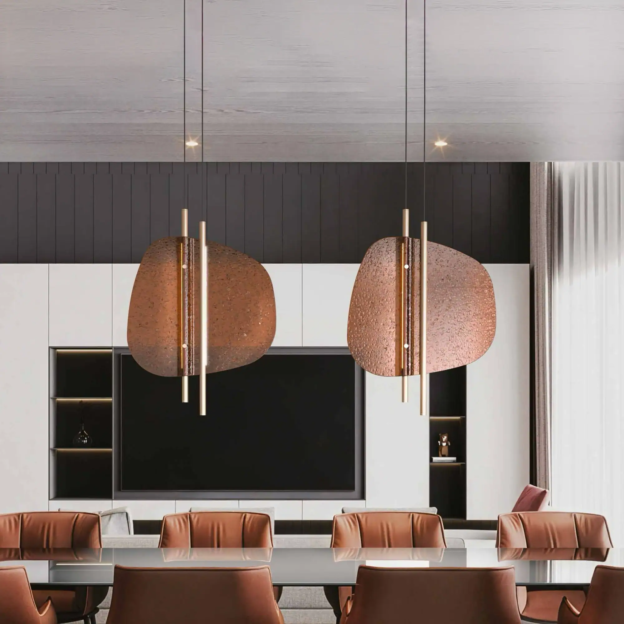 A modern dining or conference room with a glass table, brown leather chairs, and two unique copper-toned pendant lights. A large TV is integrated into a white and dark grey wall unit.