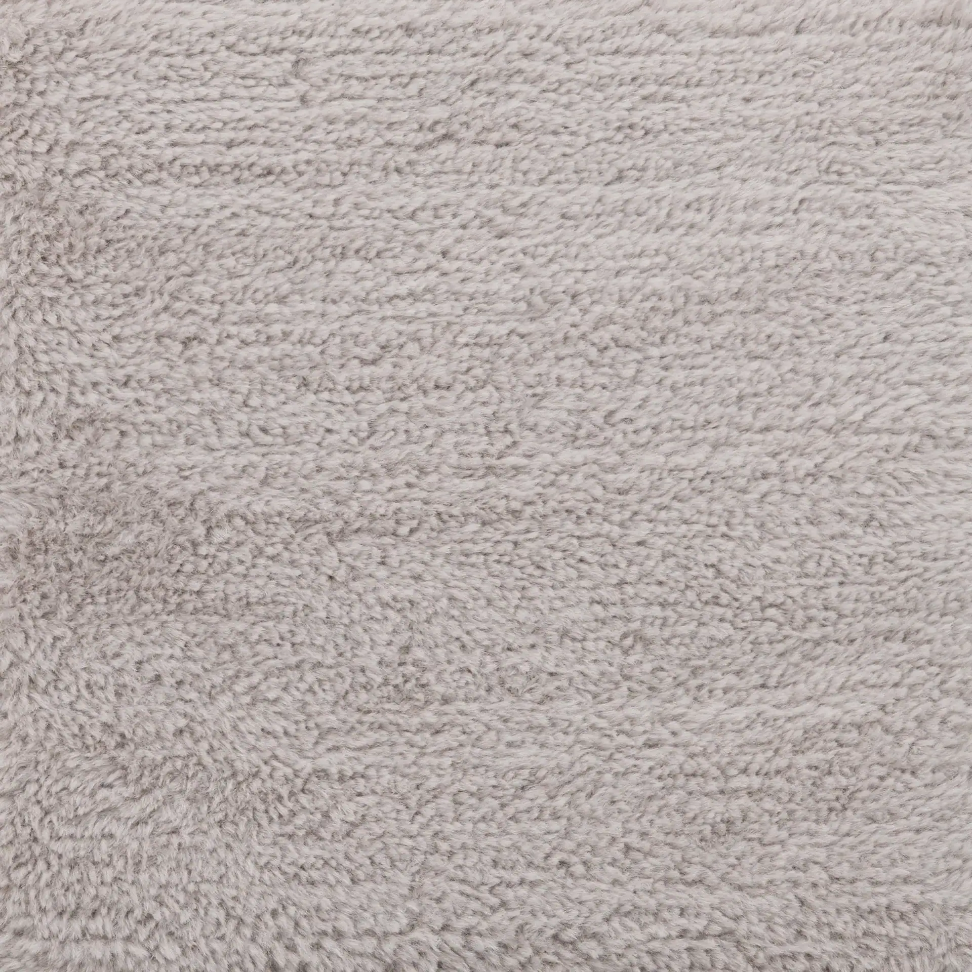 Close-up of a light gray, plush, and textured fabric surface.