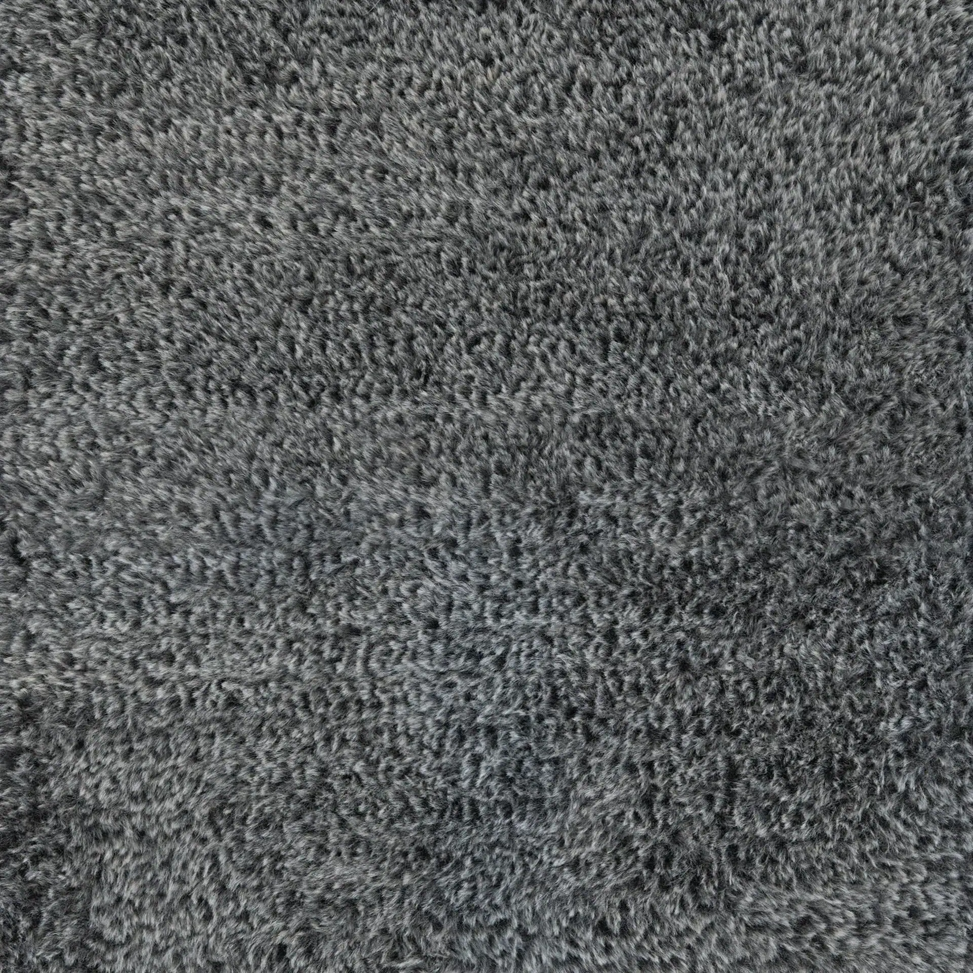 Close-up of a gray shaggy carpet or rug texture.