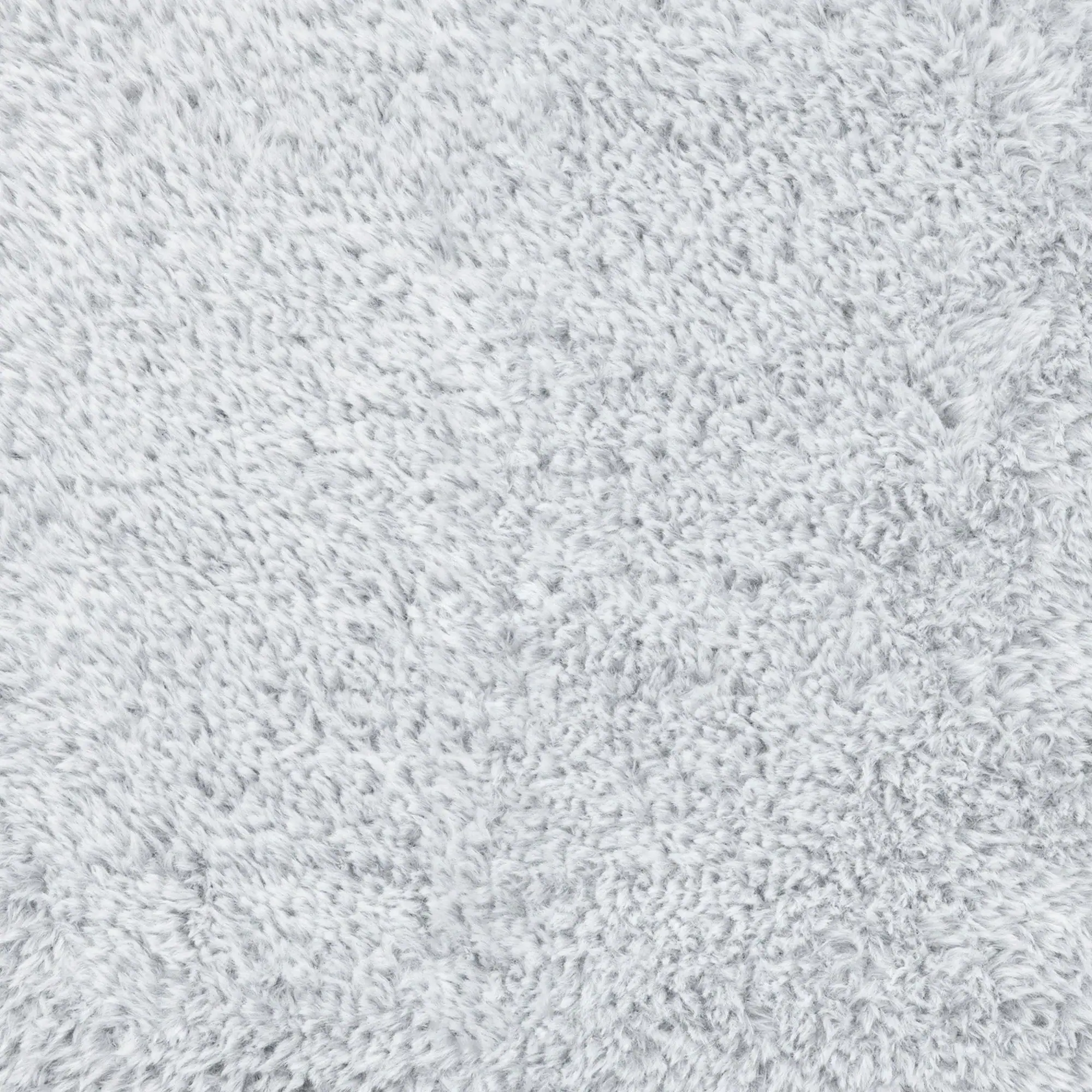 Close-up of a light gray, fluffy, and textured material, resembling faux fur or a shaggy carpet.