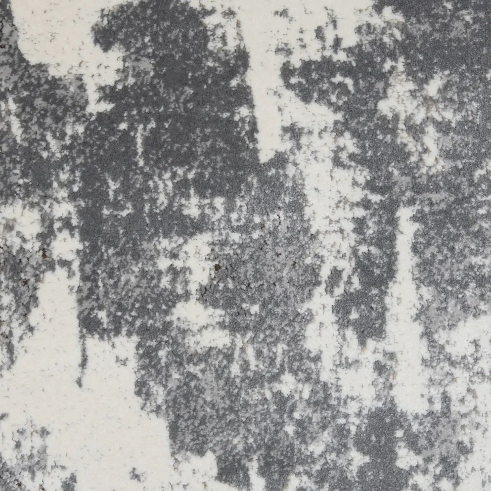 Abstract pattern of irregular off-white patches on a dark gray textured surface.