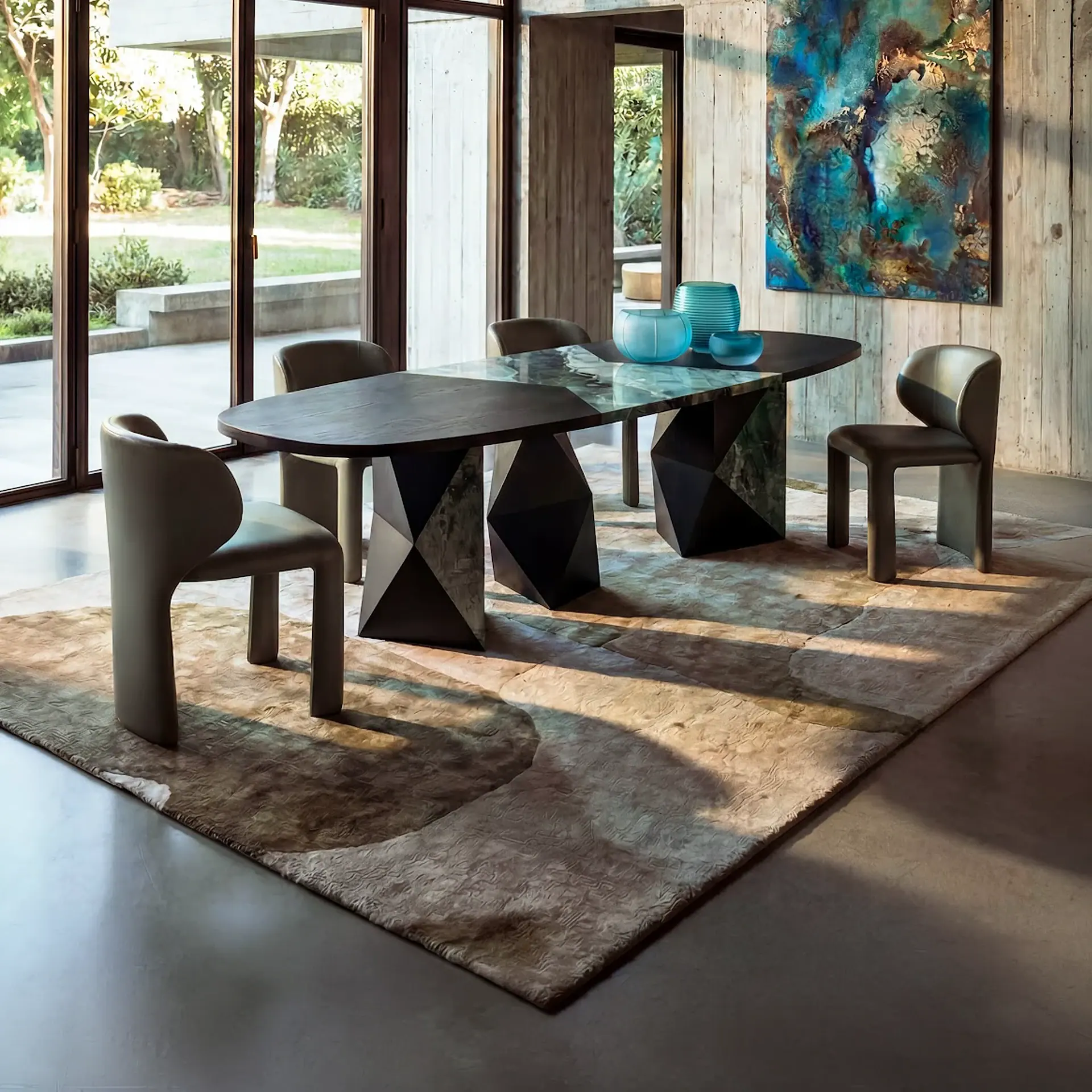 Sklar Furnishings dining table with angular black base and dark tabletop in modern dining room.