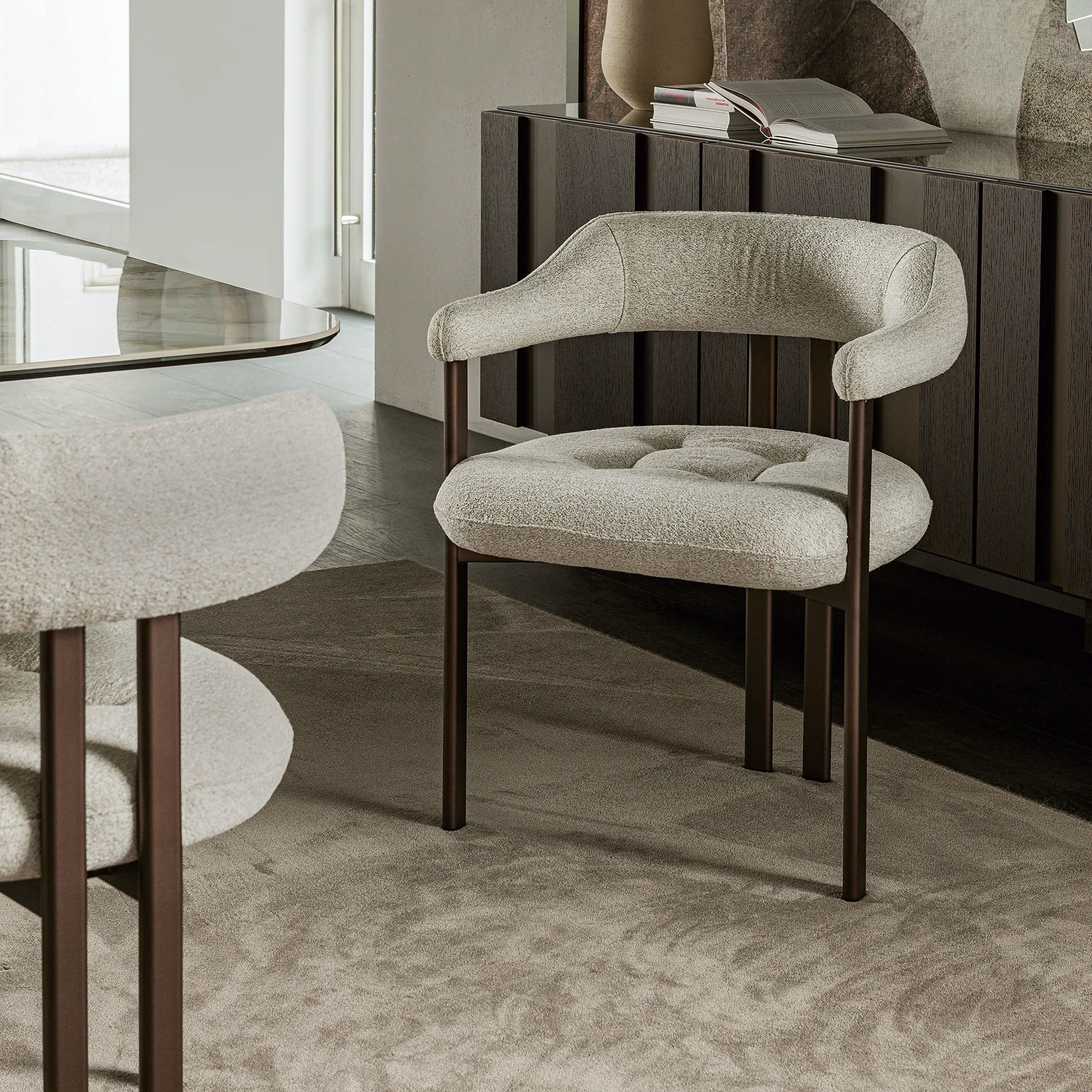 Greta Dining Armchair with light upholstery and dark wooden legs in a modern interior.