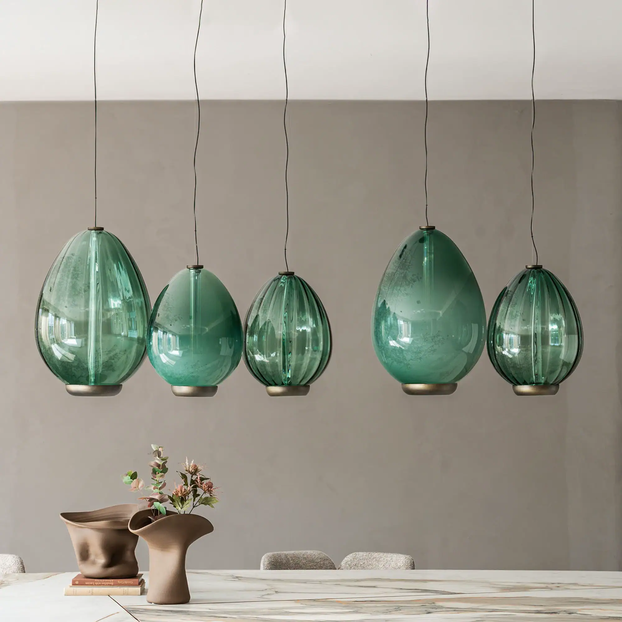 Sklar Furnishings green glass pendant lights hanging over dining table.