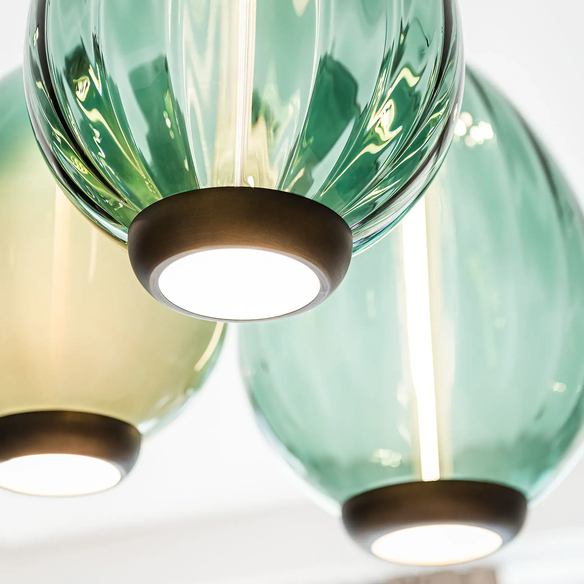 Sklar pendant light close up green glass with metal collar.