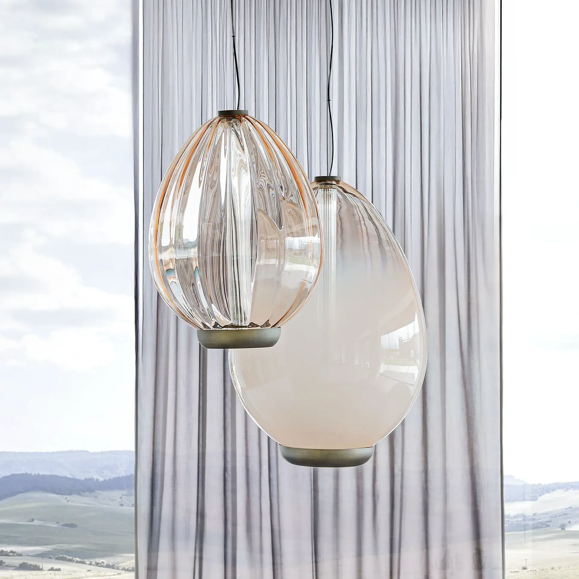 Sklar Pendant light hanging in front of sheer curtains.