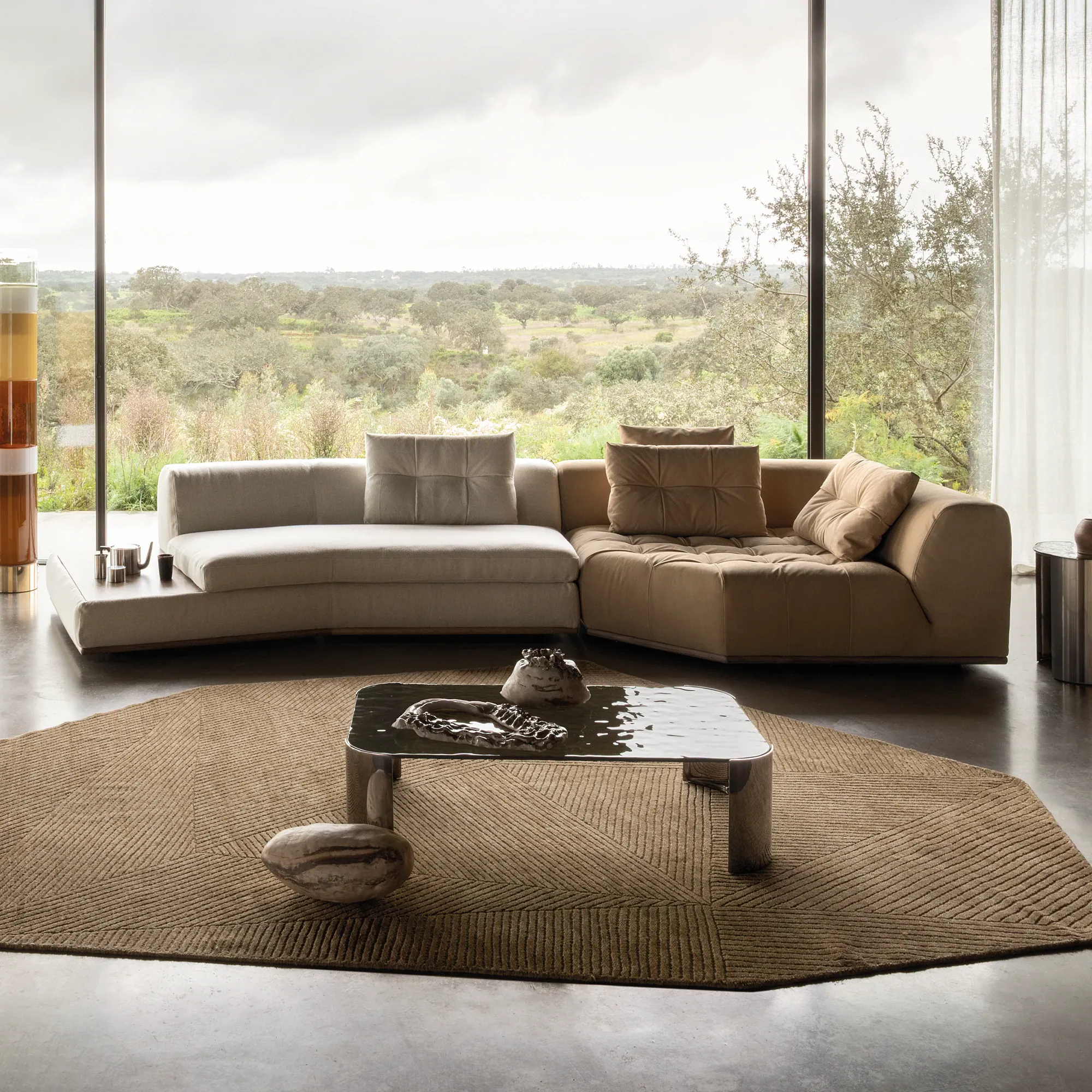 Sklar Furnishings sectional with light beige and taupe cushions in a bright living room.