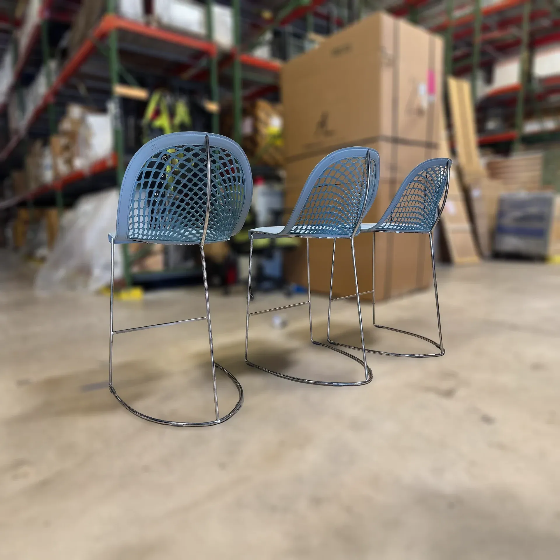 Sklar Furnishings blue molded back counter stools in a warehouse.
