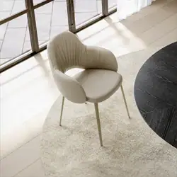 Sklar Furnishings armchair with curved back and light upholstery near window.
