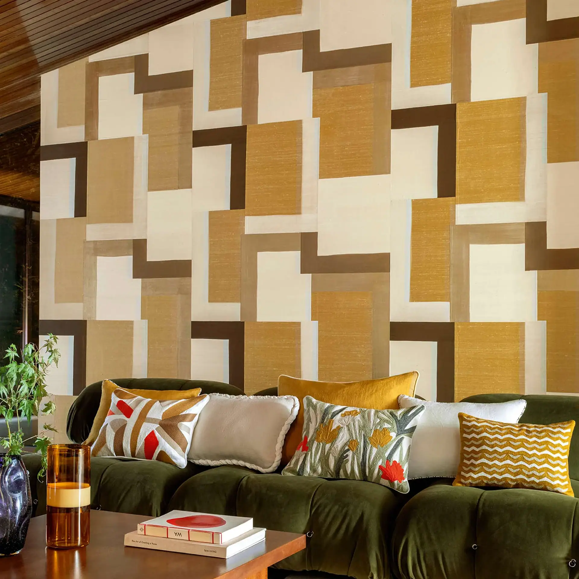 Geometric beige brown wall pattern with green sofa and decorative cushions.