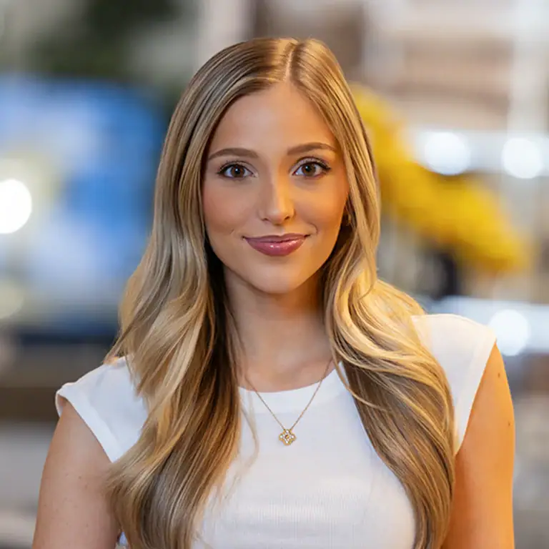 Portrait of a woman with long blonde hair in a white top.