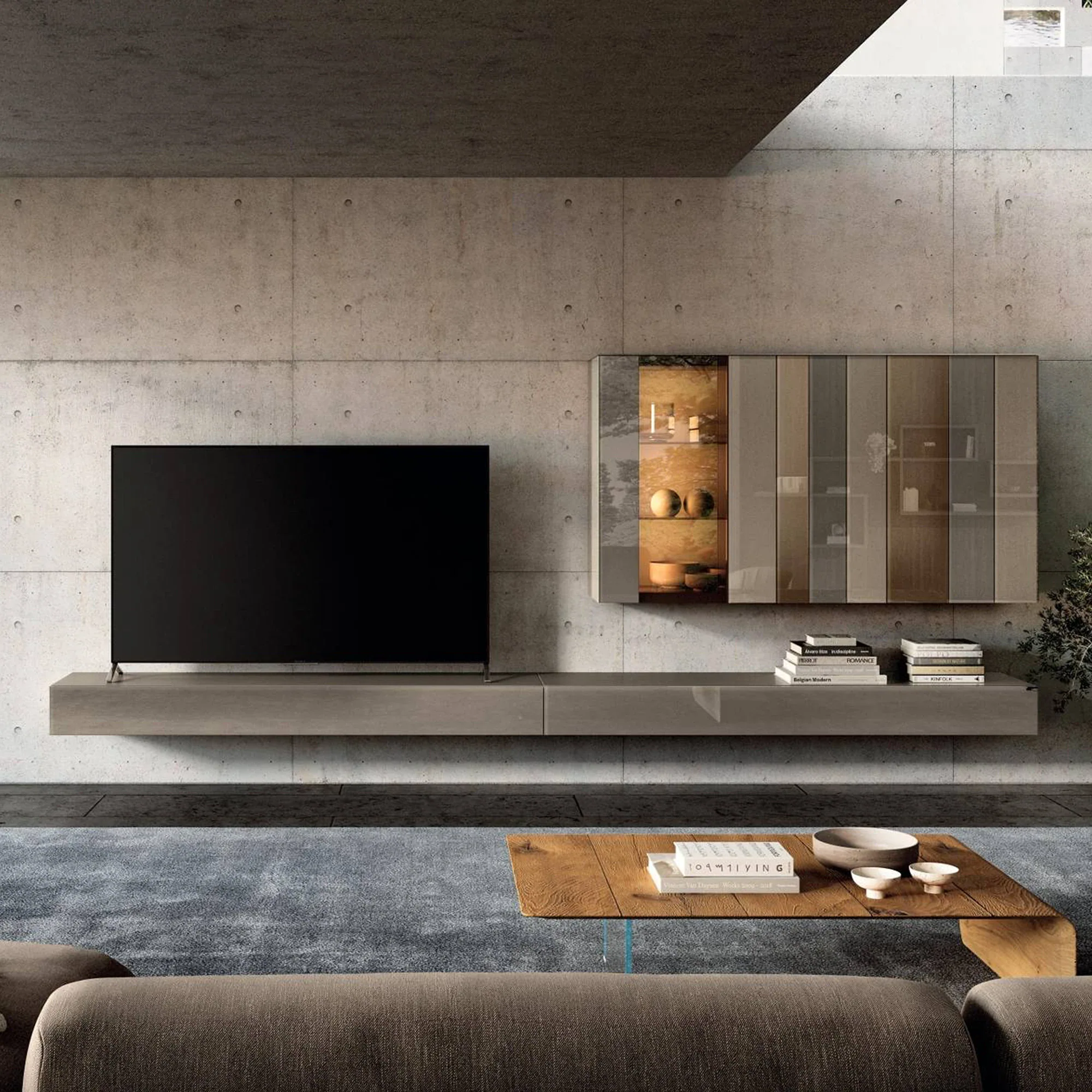 A modern living room with a concrete wall, a floating media console with a TV, a wall-mounted cabinet, a wooden coffee table, and a blue-grey rug.