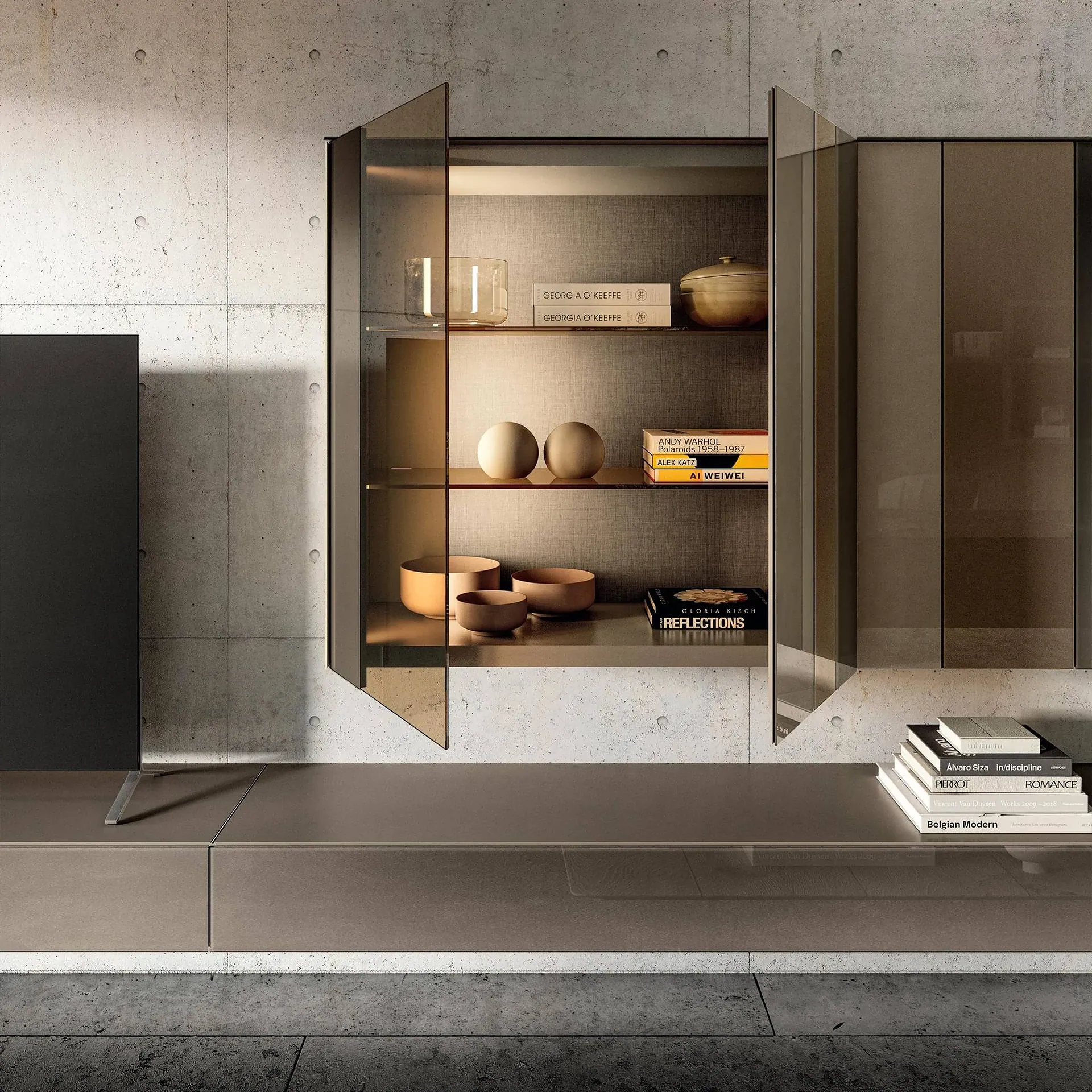 A modern display cabinet with dark glass doors and shelves, filled with books and decorative objects, mounted on a concrete wall above a matching media console.