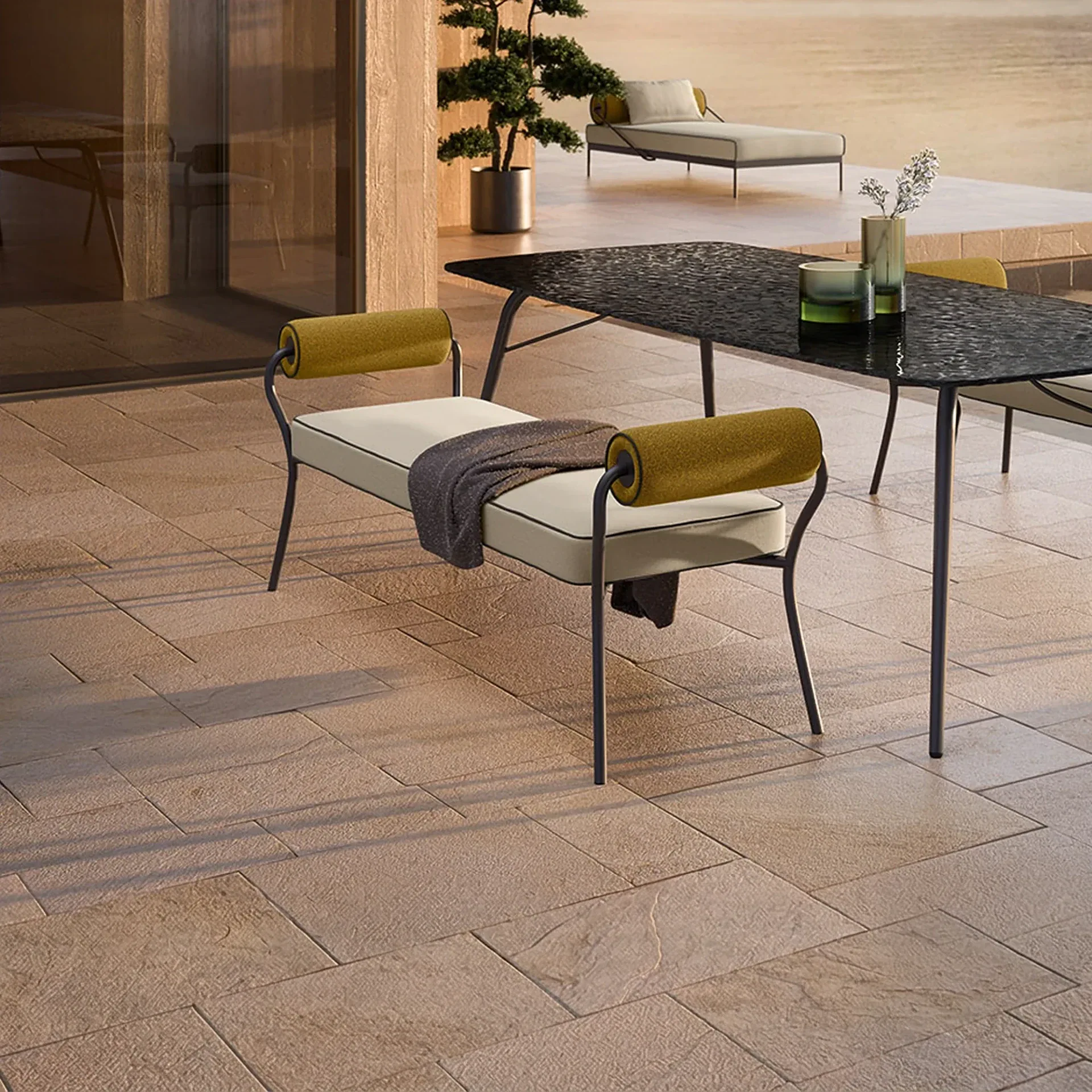 A modern outdoor patio with a bench, dining table, and chaise lounge under warm lighting.
